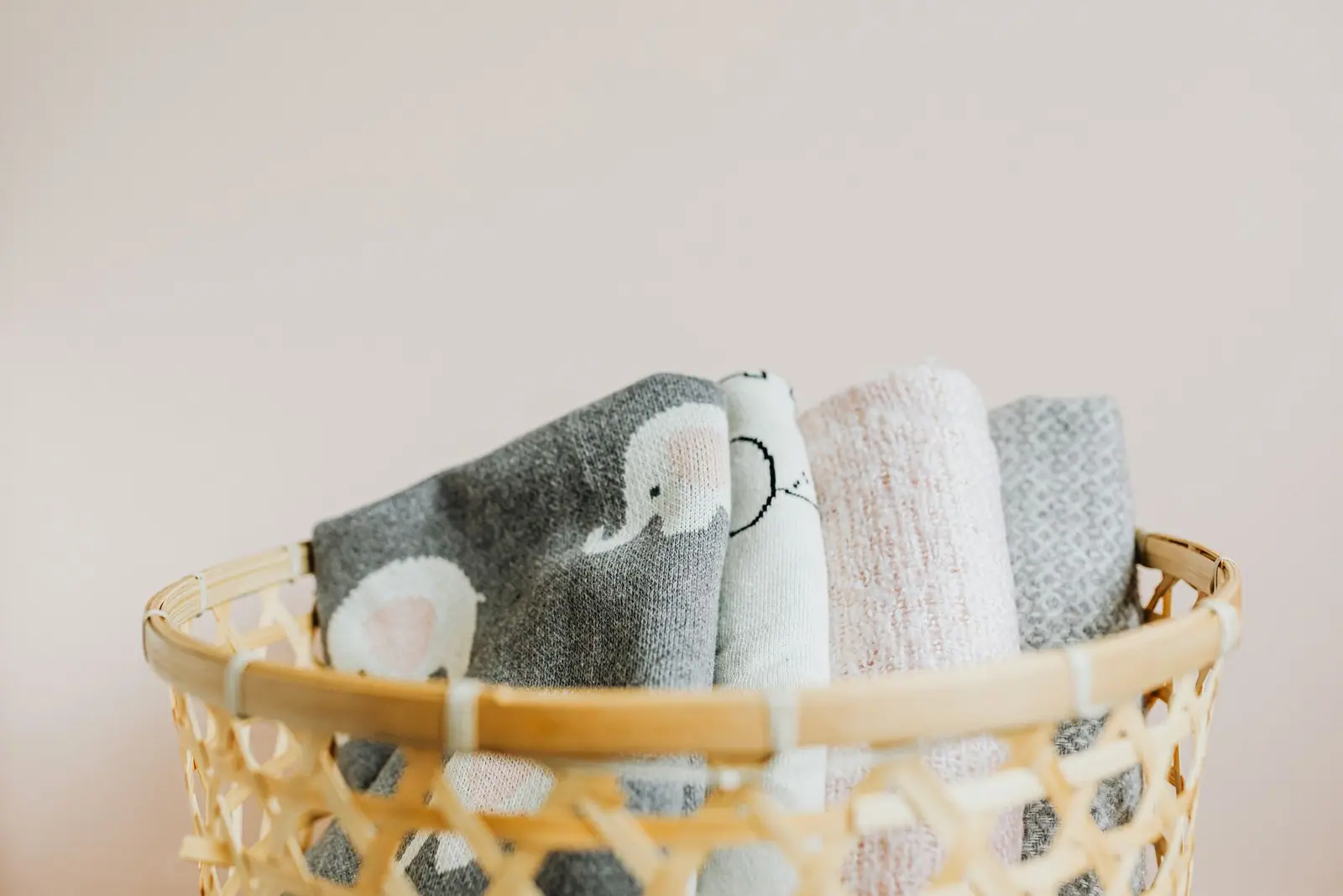 Folded baby cloths stacked in a woven basket